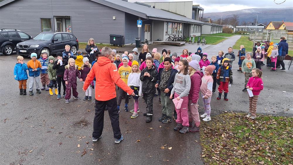 Lærer gir instruks til elever før jogging. - Klikk for stort bilde