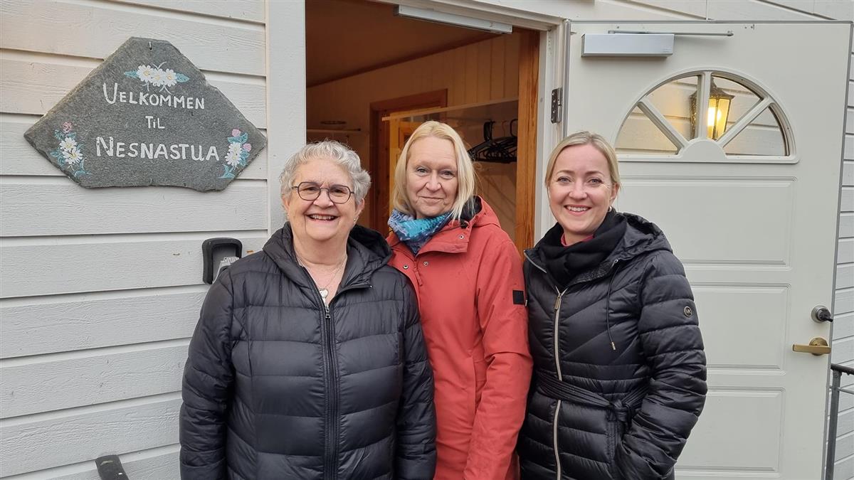 Tre kvinner foran inngangsdøra til møtestedet Nesnastua - Klikk for stort bilde